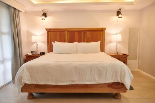 a bedroom with a large bed with two lamps on tables at Hacienda Valentino in San Cristóbal de Las Casas