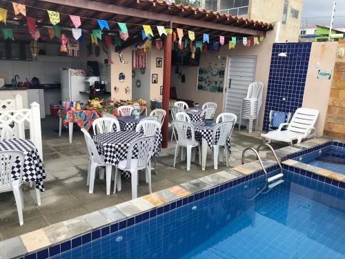 un ristorante con tavolo e sedie accanto a una piscina di Flat Rainha da Serra a Bezerros