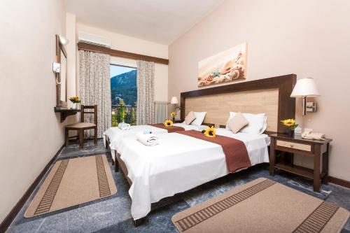 a hotel room with a large bed and a window at Potamaki Beach Hotel in Benitses