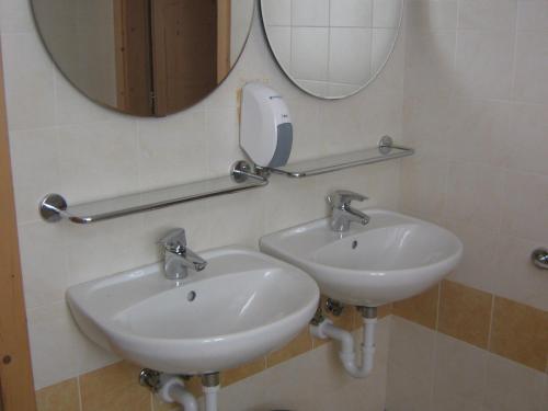 a bathroom with two sinks and a mirror at Taxus Hostel in Pieve Tesino