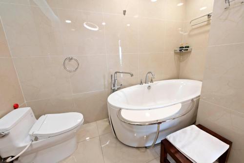 a white bathroom with a toilet and a sink at 22Land Moon West Lake in Hanoi