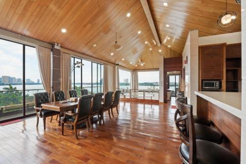 a dining room with a table and chairs and windows at 22Land Moon West Lake in Hanoi