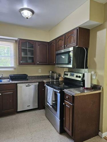 a kitchen with wooden cabinets and a stove top oven at Michele Palace in Hyattsville