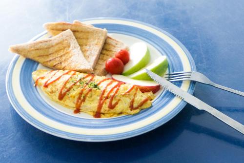 a plate of food with an omelet and crackers and fruit at Shengtuolini B&B in Yanliau