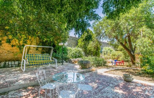 a patio with a table and chairs in a garden at 4 Bedroom Nice Home In Ragusa in Ragusa