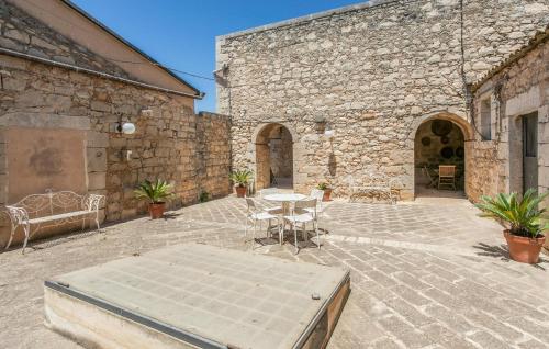 a patio with a table and chairs in a stone building at 4 Bedroom Nice Home In Ragusa in Ragusa