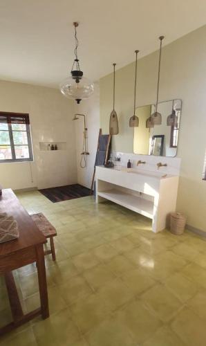 a living room with a table and a mirror at Villa SOWILO Penida in Polilit