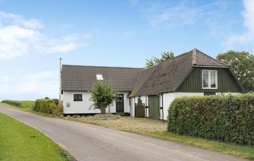 a white house with a black roof and a road at 1 Bedroom Amazing Home In Stubbekøbing in Stubbekøbing