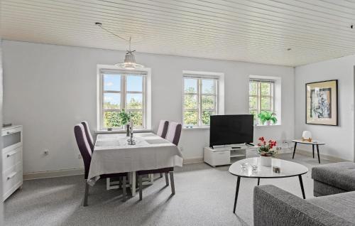 a living room with a table and a tv at 1 Bedroom Amazing Home In Stubbekøbing in Stubbekøbing