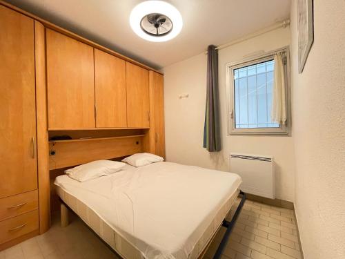 une petite chambre avec un lit et une fenêtre dans l'établissement T2 avec loggia vitrée, terrasse, parking à Sète - FR-1-338-589, à Sète