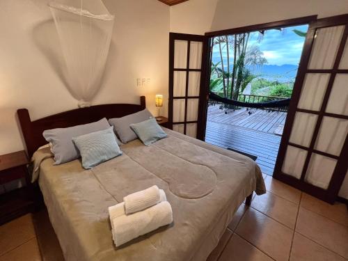 a bedroom with a large bed with a large window at Pousada Tagomago in Abraão