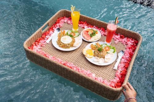 un vassoio di cibo su un tavolo in acqua di Daruma Villa Sebatu ad Ubud