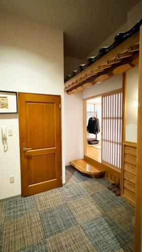 a room with a wooden door and a hallway at Yufuin Tabinokura in Yufuin