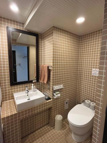 a bathroom with a sink and a toilet and a mirror at Sutton Place Hotel Ueno in Tokyo