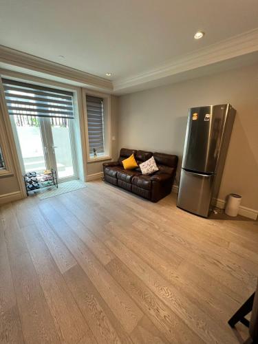 a living room with a refrigerator and a couch at Private Rooms in Vancouver West in Vancouver