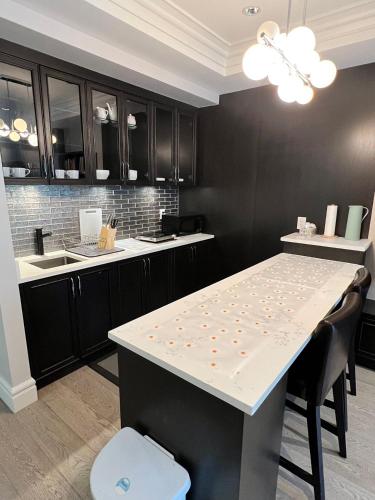 a kitchen with a white table and black cabinets at Private Rooms in Vancouver West in Vancouver