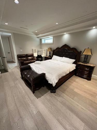 a large bedroom with a large bed and leather furniture at Private Rooms in Vancouver West in Vancouver