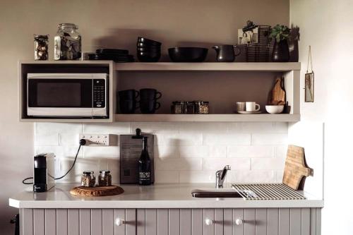 a kitchen counter with a microwave and a sink at Ship Inn Stanley in Stanley