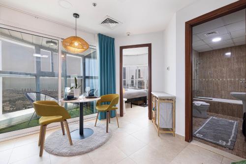 a room with a table and chairs and a bathroom at Stunning Panoramic Sea & Marina City Skyline View in Dubai