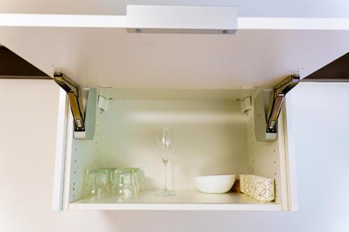 a shelf with a wine glass and other items at T2 L'Escale du Voyageur - Terrasse Jardin & Jacuzzi - Proche Aéroport in Sainte-Marie