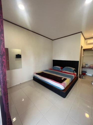 a bedroom with a bed in the corner of a room at The SeaShell Chalet Melaka Kuala Sg Baru in Kampung Kuala Linggi