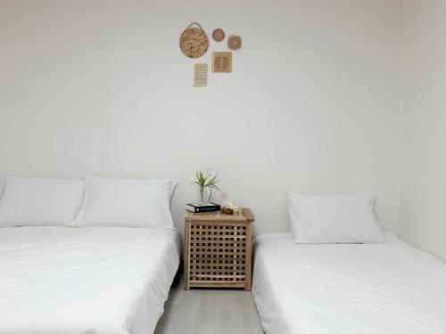 two beds in a room with white walls at Jamsil Seokchon-dong #Lotteworld #Seokchonlake #Lottetower #KSPO DOME #stadium in Seoul