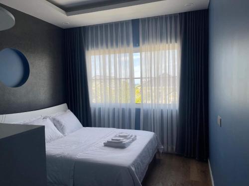 a bedroom with a bed and a large window at Holiday Villa Novaworld Phan Thiet in Phan Thiet