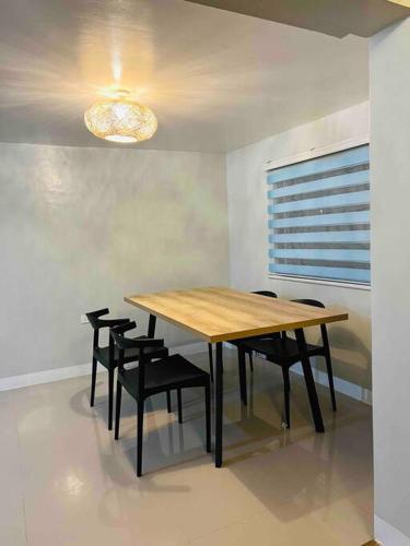 a dining room with a wooden table and black chairs at Babak Point Inland Resort - Exclusive Home with Pool in Samal in Babak