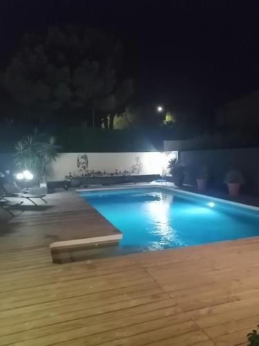 une piscine éclairée la nuit dans l'établissement Villa piscine, spa & pétanque à Uzès centre !, à Uzès