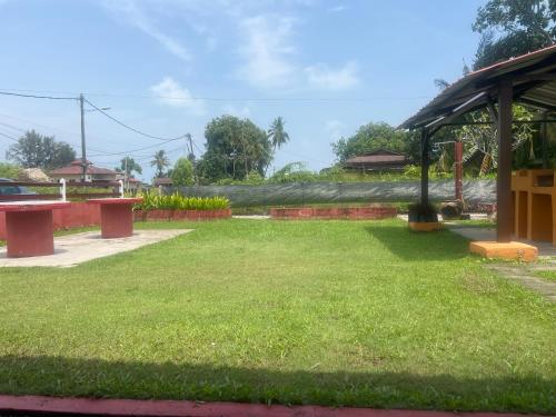 a tree that is laying on the grass at The SeaShell Chalet Melaka Kuala Sg Baru in Kampung Kuala Linggi