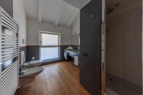 un bagno con due WC e un lavandino di La Barchessa Loft & Rooms - Free parking a Trento