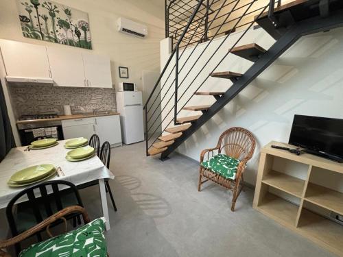 a kitchen and dining room with a table and a staircase at Loft 1-2-3, in centro, con giardino, a 150 m dal mare in Pineto