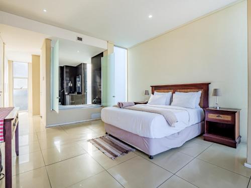 a bedroom with a large white bed and a window at The Quays at Point Waterfront Durban in Durban
