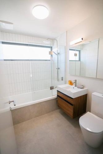 a bathroom with a toilet and a sink and a tub at Abodo Alpine Eco Villa in Cardrona