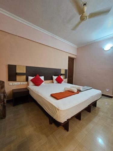 a bedroom with a large bed with red pillows at The Pentacon A Resort in Canacona