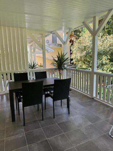 a porch with a wooden table and chairs on it at Szem-s Vendégház in Balatonszemes