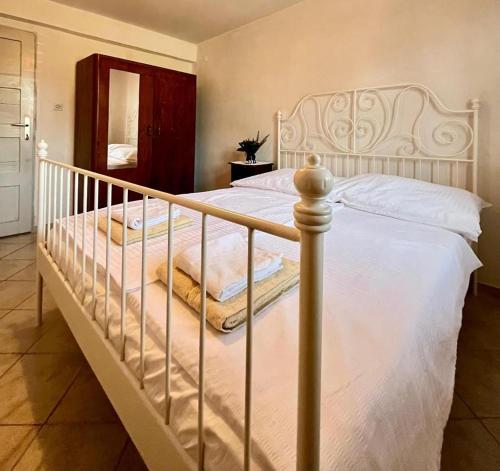 a bedroom with a white bed with a metal frame at Vila Klara rooms in Olib