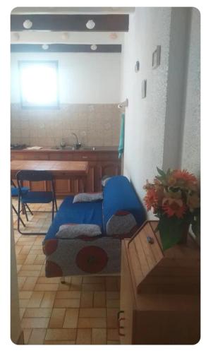 a living room with a blue bed and a table at App ensoleillé Guéthary classé 2 * avec terrasse et jardin privatifs in Guéthary