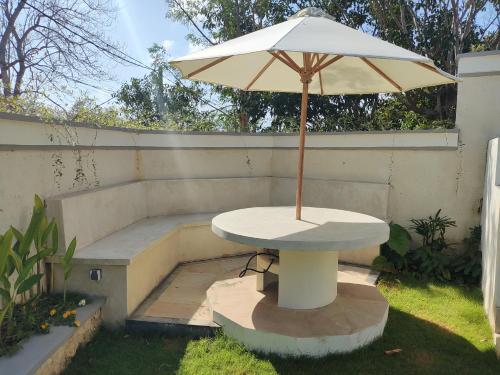 a table with an umbrella on a patio at Joglow Clasica Uluwatu in Uluwatu