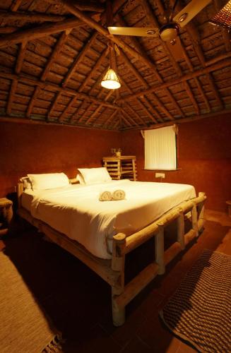 a bedroom with a large bed in a room at The Soul Marayoor Mudhouse - Munnar in Marayoor