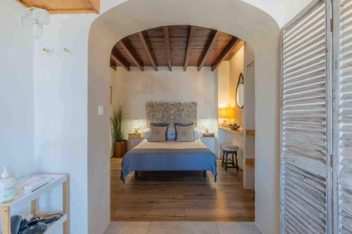 a bedroom with a bed with a blue bedspread at La Tartana Hotel Boutique in La Herradura