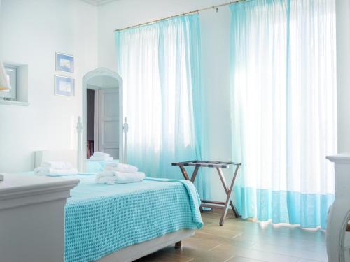a blue bedroom with a bed and a mirror at Heliades Maisonettes in Mithymna