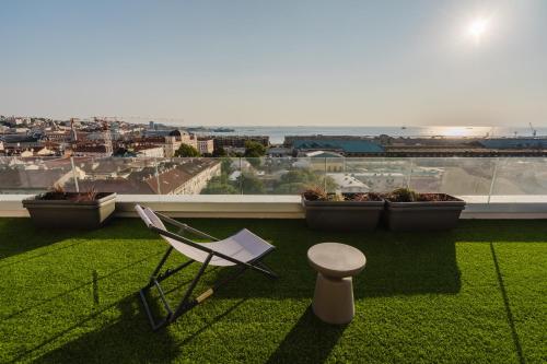 a chair and a stool on a balcony with a view at Casanova Bluelife in Trieste