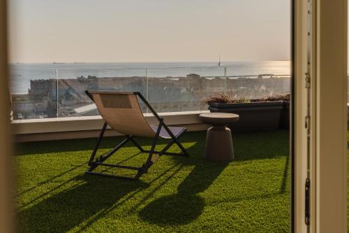 a chair and a table in front of a window at Casanova Bluelife in Trieste