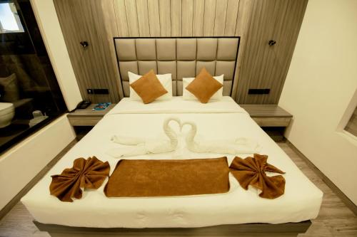 two swans made out of towels on a bed at Goodland Elegance in Trivandrum