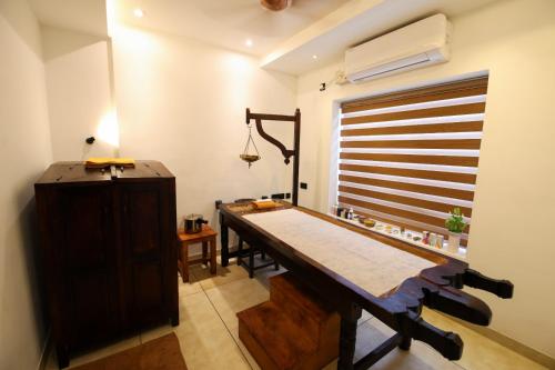 a dining room with a table and a window at Goodland Elegance in Trivandrum