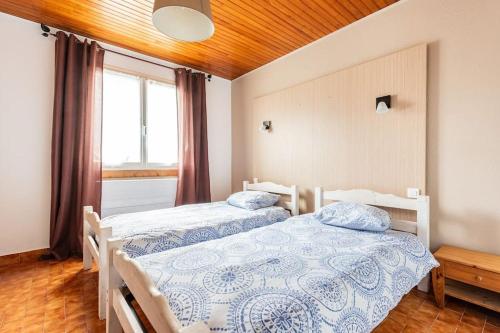une chambre avec deux lits et une fenêtre dans l'établissement T3 à St Pons en rez de jardin, à Saint-Pons