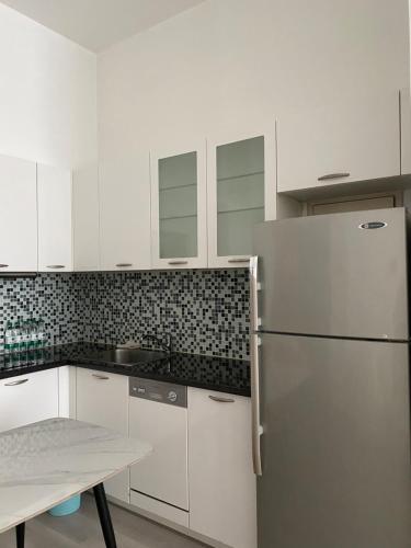 a kitchen with white cabinets and a stainless steel refrigerator at River House Near The Peoples Square And The Bund in Shanghai