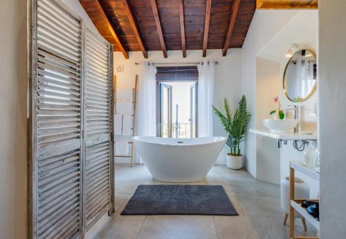 a bathroom with a large tub and a sink at La Tartana Hotel Boutique in La Herradura