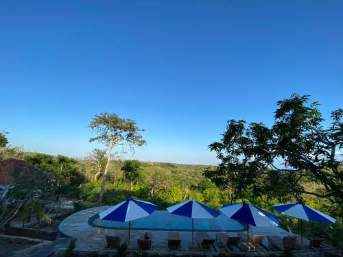 a group of blue and white umbrellas and chairs at Kubuhill Sunset Bungalow in Nusa Penida
